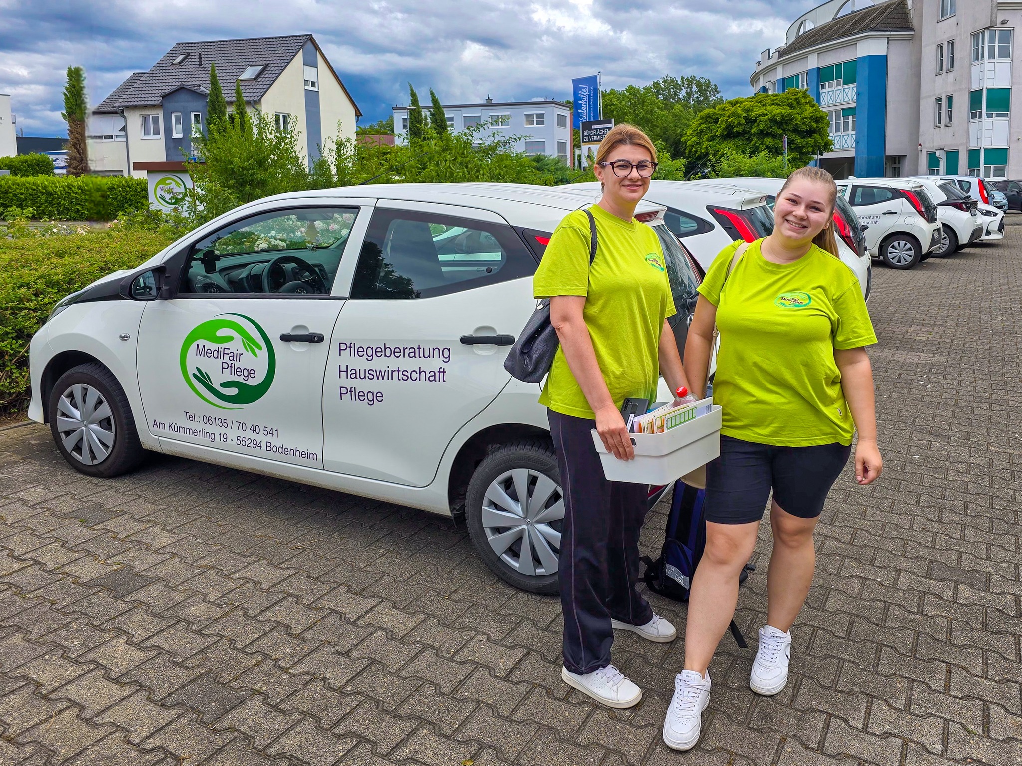Mitarbeiter MediFair Pflege vor Dienstwagen